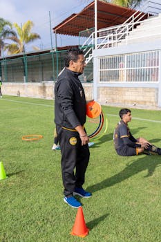 A soccer coach instructs young players on a sunny day at a training field in Texcoco, Mexico.